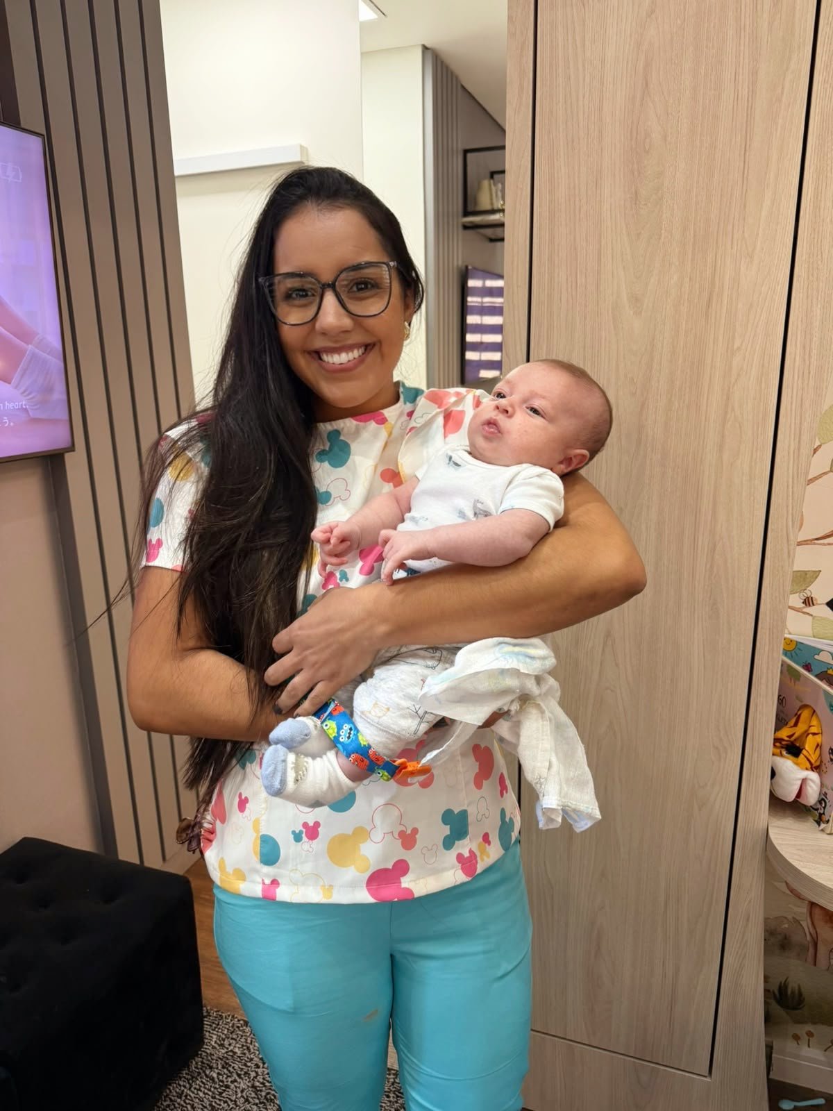 Dra. Fernanda Braz segurando um bebê no consultório